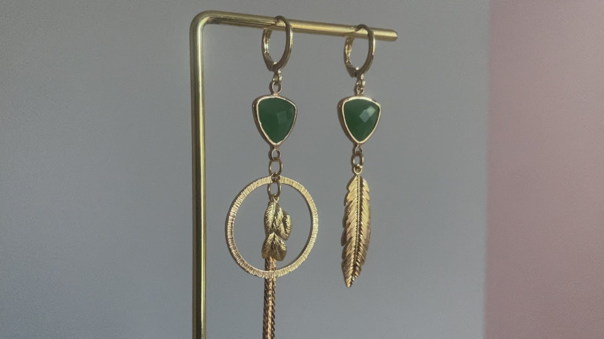 Filmpje van Handgemaakt asymmetrische oorbellen met groene glasbedels, 14K vergulde gehamerde bedels in een ring en blaadjes.