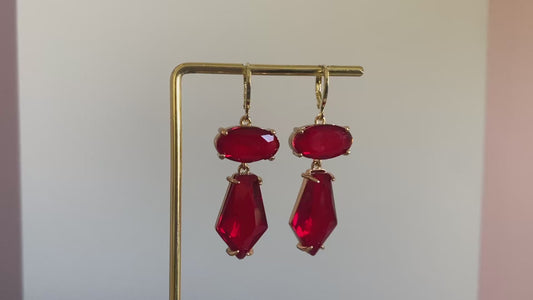 Filmpje van Handgemaakte statement oorbellen met rode glasbedels in ovalen en vijfhoekige bedel aan een 14K verguld oorringetje.