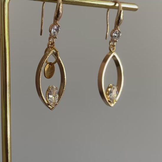 Filmpje van 14K vergulde oorbellen met haakjes met zirkonia steen, druppelvormige hangers met daarin een zirkonia steen een het Lellebel sieraden logo