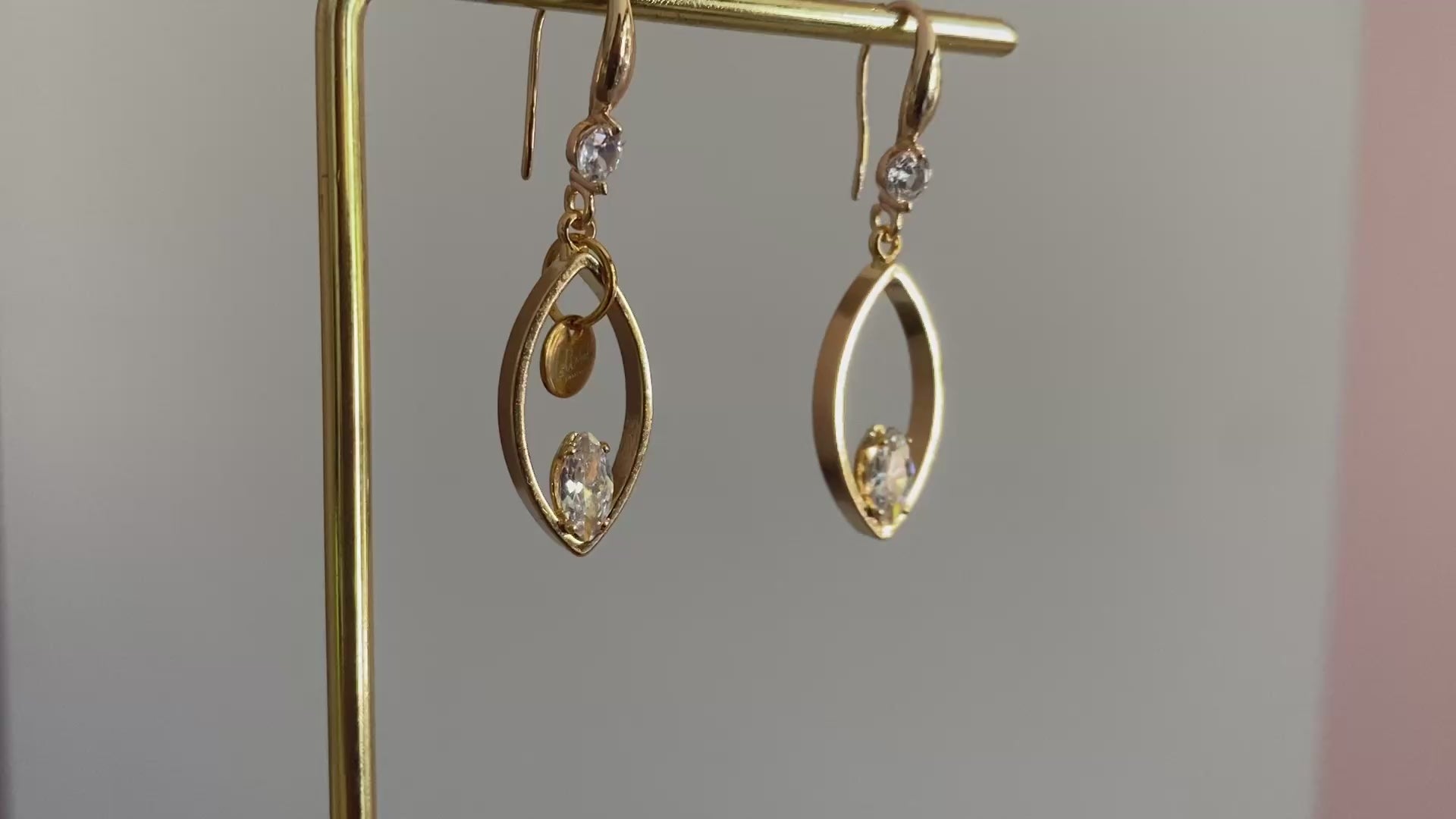 Filmpje van 14K vergulde oorbellen met haakjes met zirkonia steen, druppelvormige hangers met daarin een zirkonia steen een het Lellebel sieraden logo