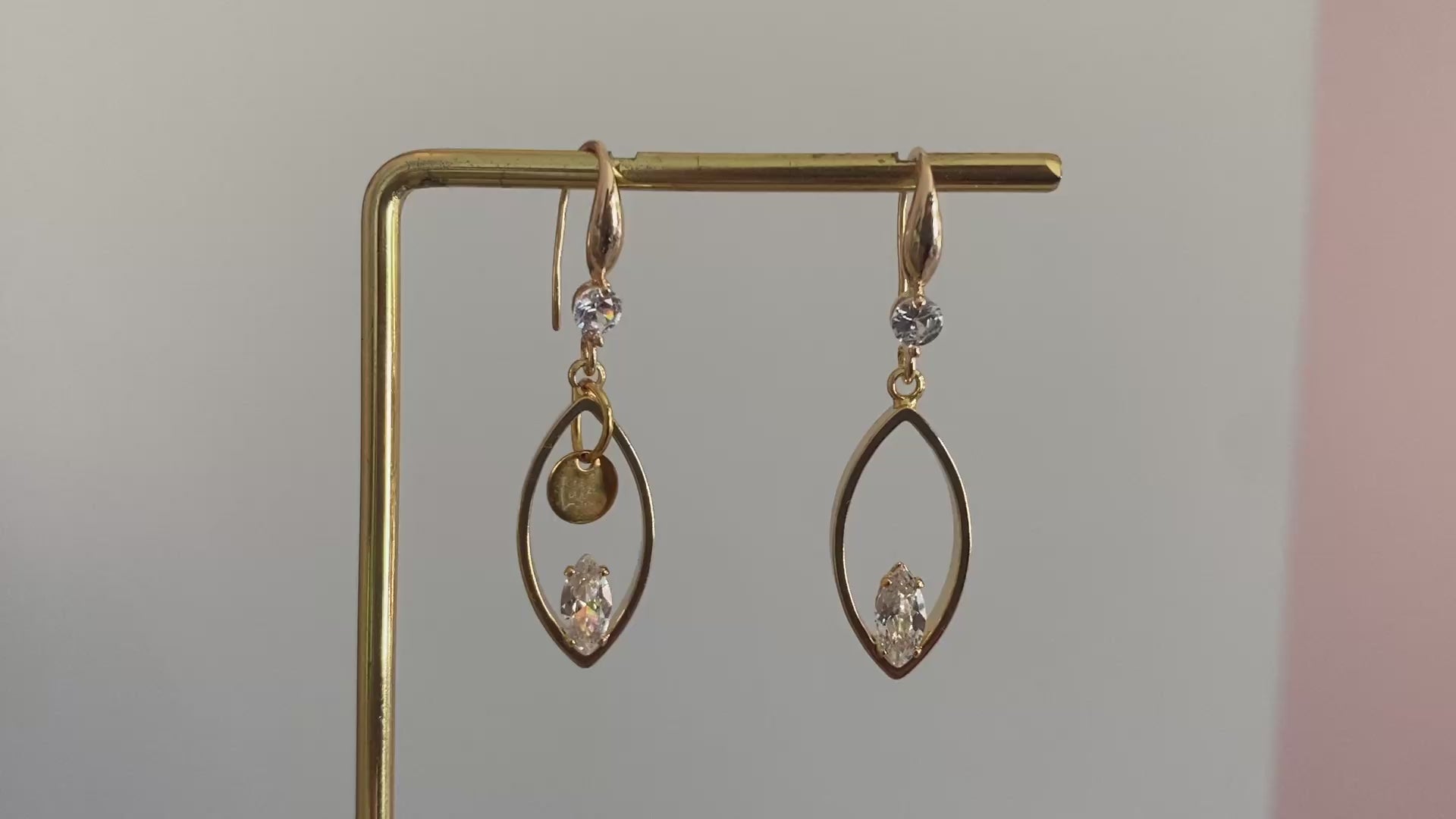 Filmpje van 14K vergulde oorbellen met haakjes met zirkonia steen, druppelvormige hangers met daarin een zirkonia steen een het Lellebel sieraden logo