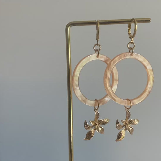 Filmpje van Statement oorbellen met 14K vergulde bloemen en een perzikkleurige resin hanger. 