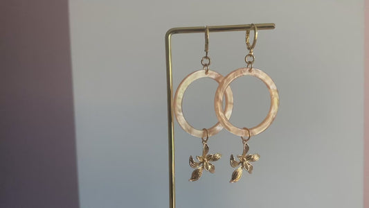 Filmpje van Statement oorbellen met 14K vergulde bloemen en een perzikkleurige resin hanger. 