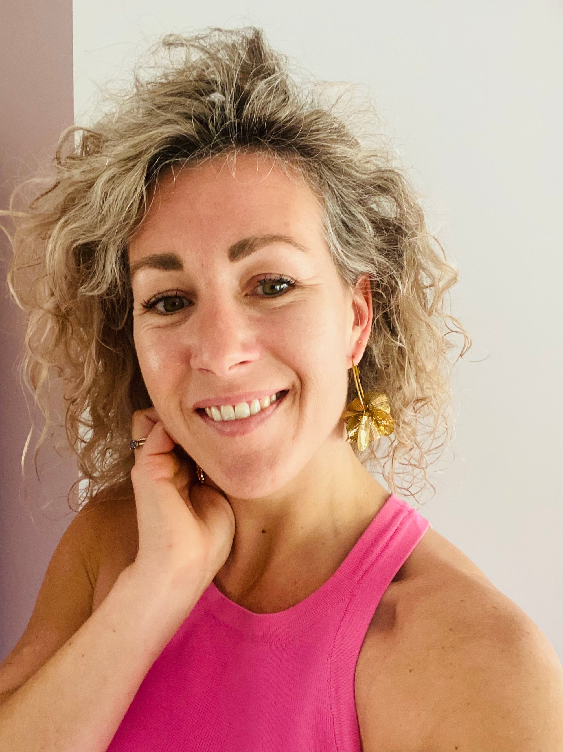 Model met statement bloem oorbel gemaakt van verguld RVS.