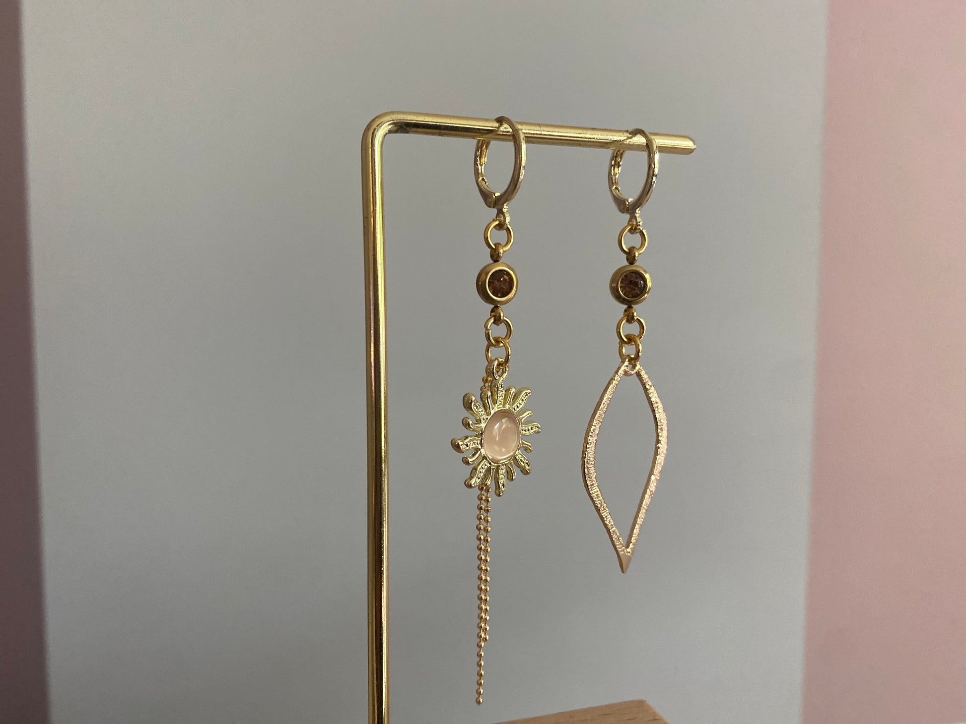 Asymmetrische oorbellen van 14K verguld goud met een zon van een cateye steen en een gehamerde 14K vergulde druppelvormige hanger en dieporanje zirkonia bedeltjes.