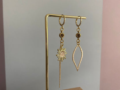 Asymmetrische oorbellen van 14K verguld goud met een zon van een cateye steen en een gehamerde 14K vergulde druppelvormige hanger en dieporanje zirkonia bedeltjes.