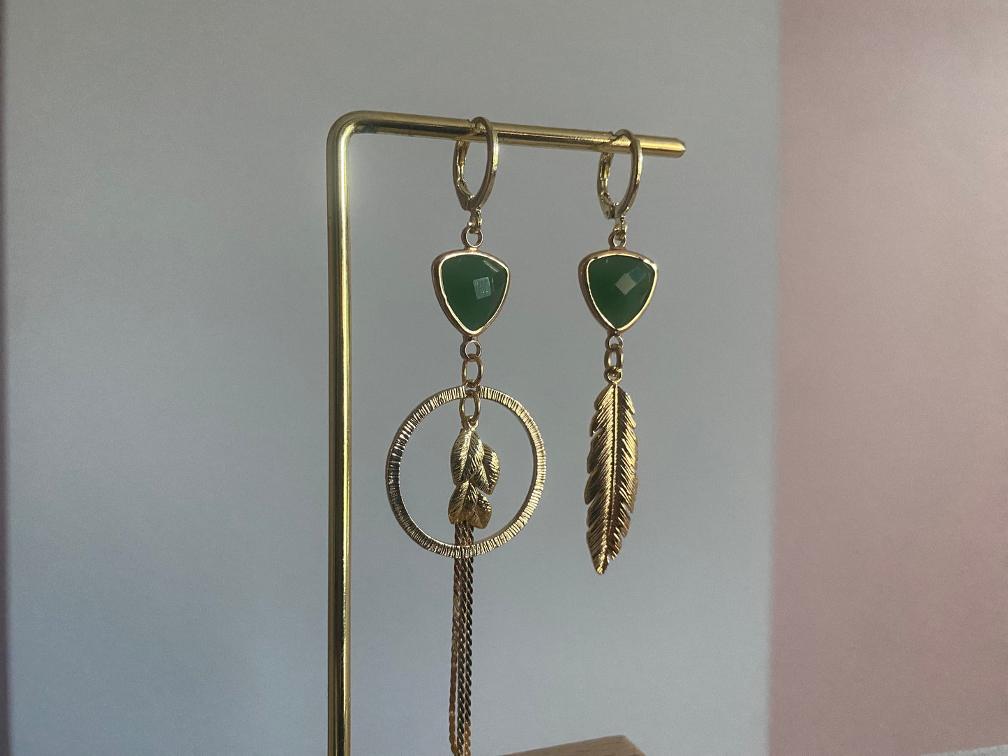 Handgemaakt asymmetrische oorbellen met groene glasbedels, 14K vergulde gehamerde bedels in een ring en blaadjes.