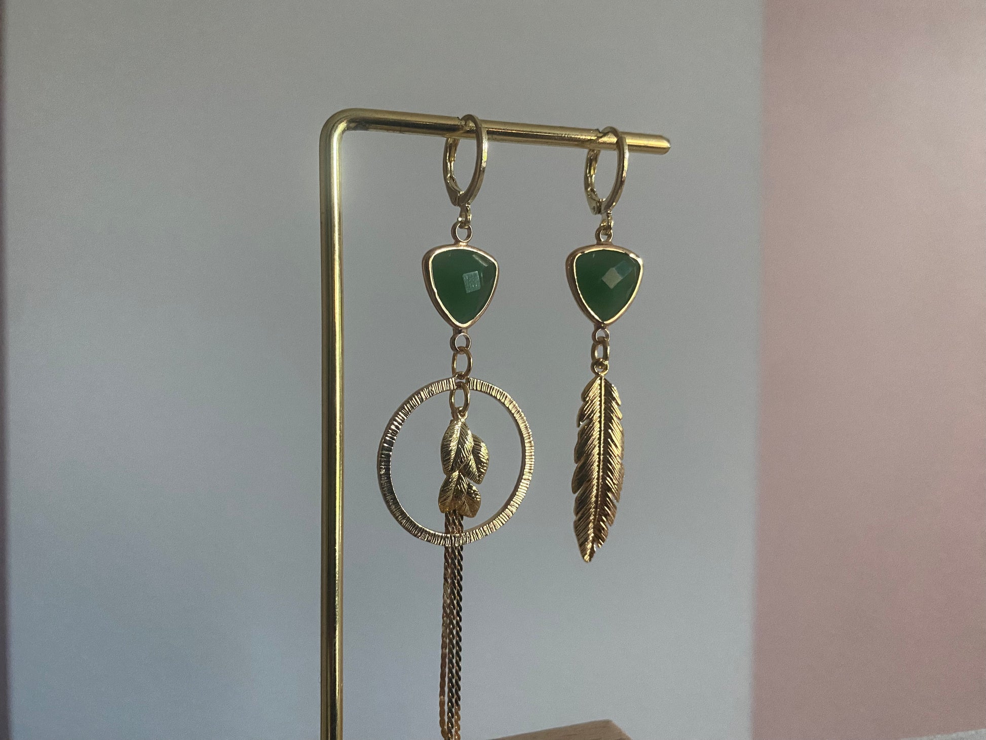 Handgemaakt asymmetrische oorbellen met groene glasbedels, 14K vergulde gehamerde bedels in een ring en blaadjes.