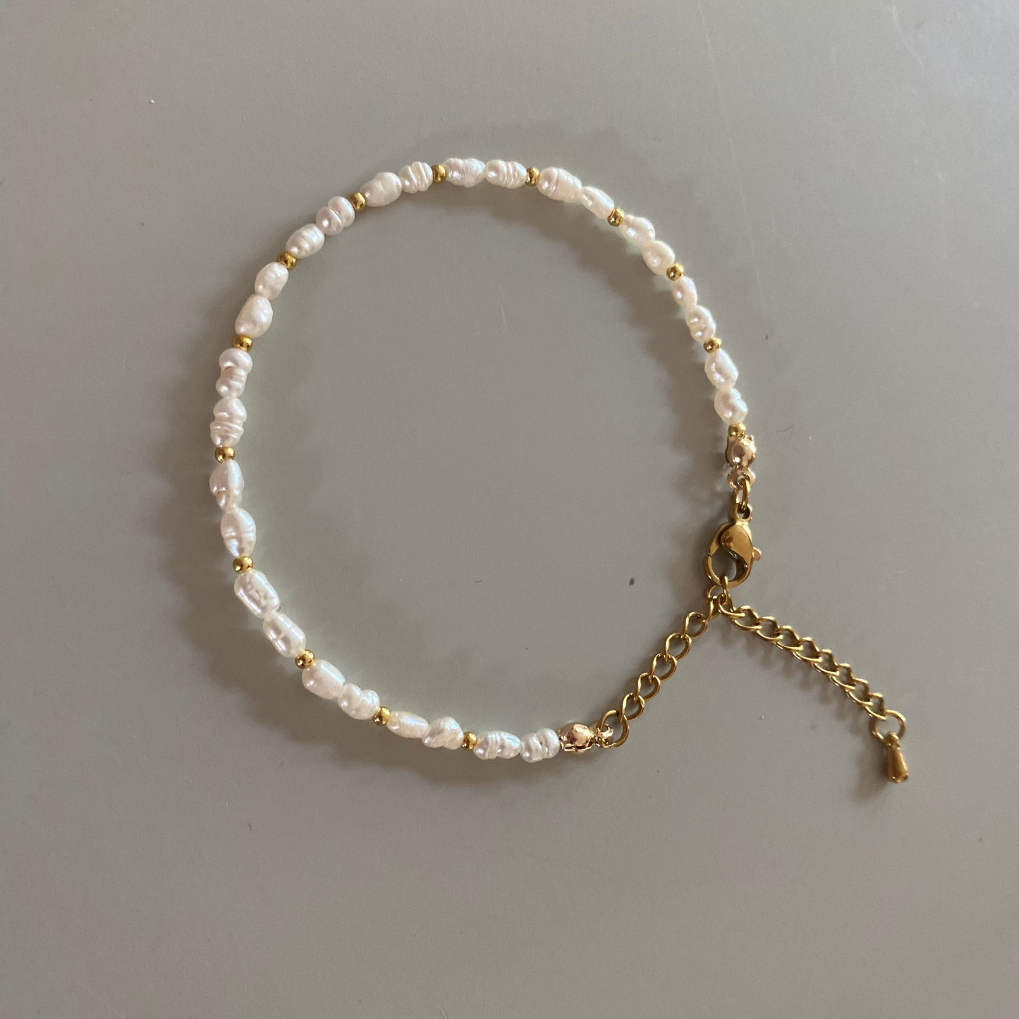Set van armband en ring met echte zoetwaterparels (2–3 mm) en goldfilled kralen, armband tot 20 cm met sluiting, ring met elastiek.